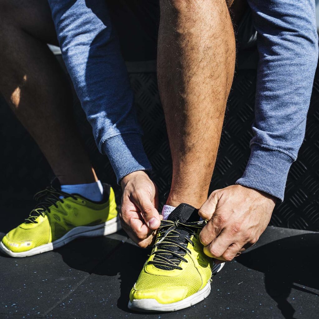 persona poniéndose las zapatillas para hacer running